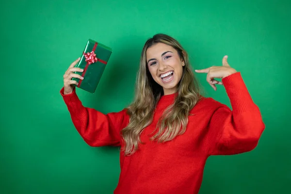 Jovem Menina Bonita Segurando Presente Sobre Fundo Verde Isolado Fazendo — Fotografia de Stock