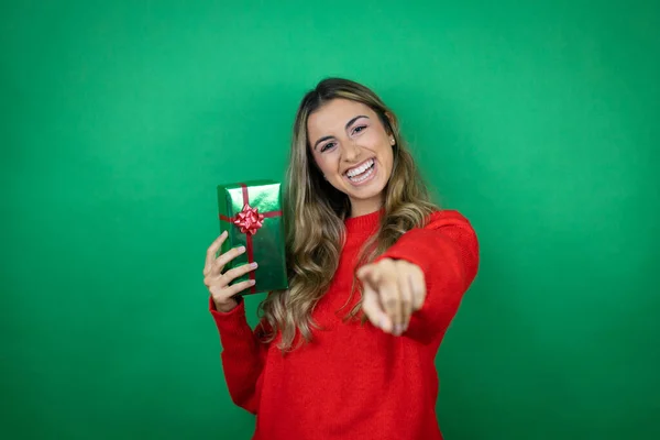 Joven Chica Hermosa Sosteniendo Regalo Sobre Fondo Verde Aislado Riéndose —  Fotos de Stock