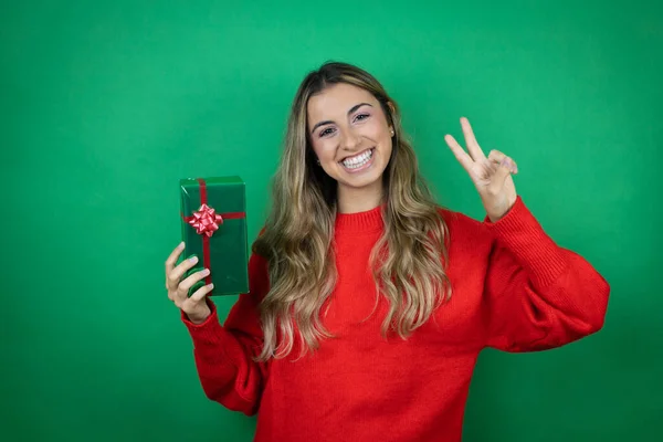 Menina Bonita Jovem Segurando Presente Sobre Fundo Verde Isolado Mostrando — Fotografia de Stock