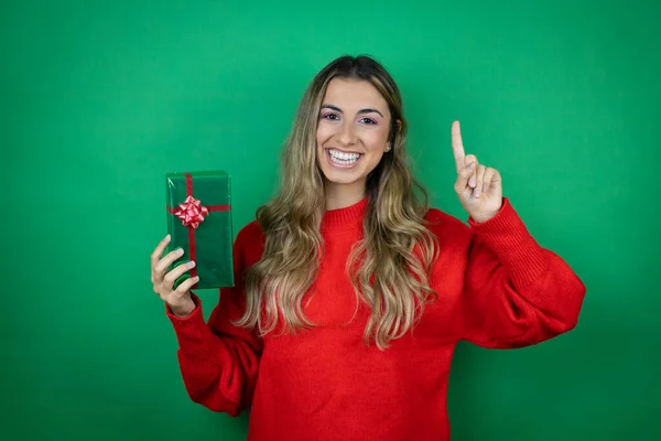 Giovane Bella Ragazza Possesso Regalo Sfondo Verde Isolato Mostrando Indicando — Foto Stock