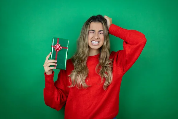 Jovem Menina Bonita Segurando Presente Sobre Fundo Verde Isolado Sofrendo — Fotografia de Stock