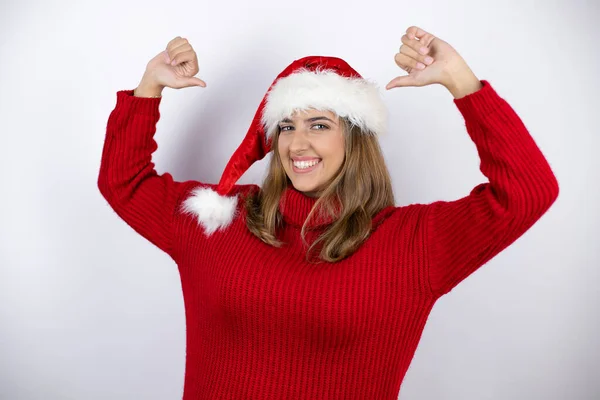 원피스를 금발의 여성과 크리스마스 모자를 위에서 웃으면서 자랑스럽고 손가락으로 자신을 — 스톡 사진