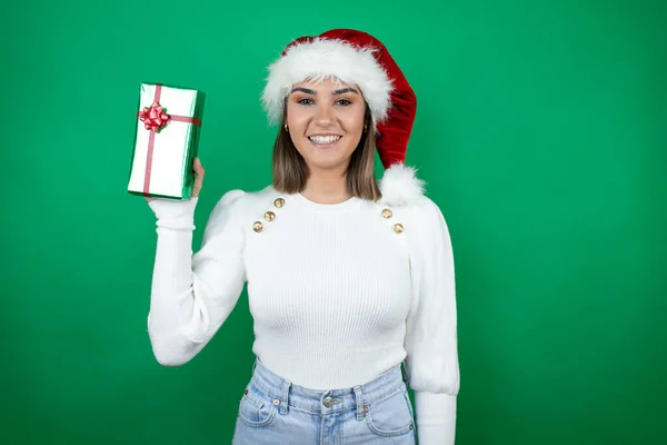 Joven Hermosa Mujer Con Sombrero Santa Sosteniendo Regalo Suéter Blanco — Foto de Stock