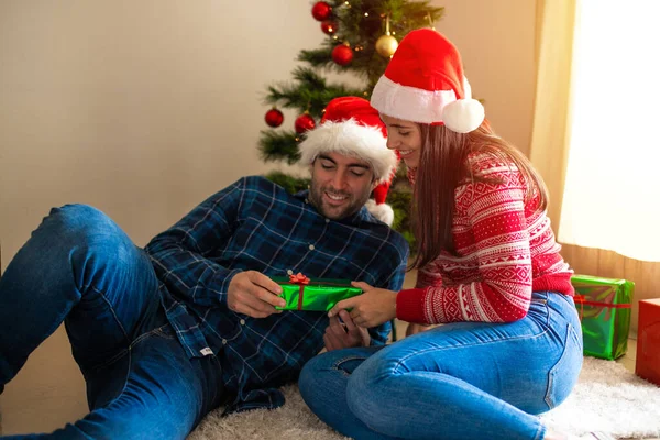 Jeune Couple Souriant Donnant Cadeau Avec Arbre Noël Arrière Plan — Photo