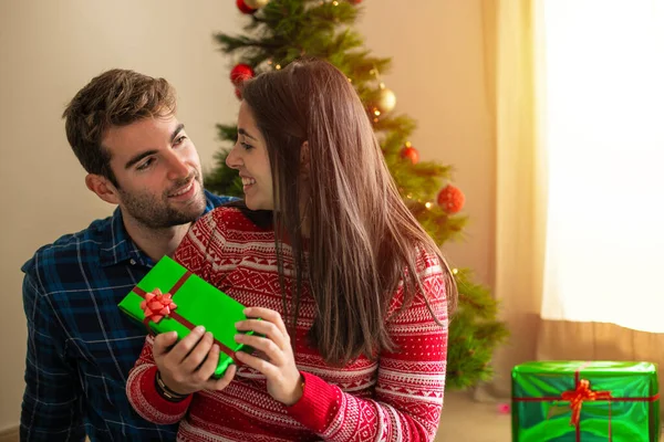 Jeune Couple Souriant Donnant Cadeau Avec Arbre Noël Arrière Plan — Photo