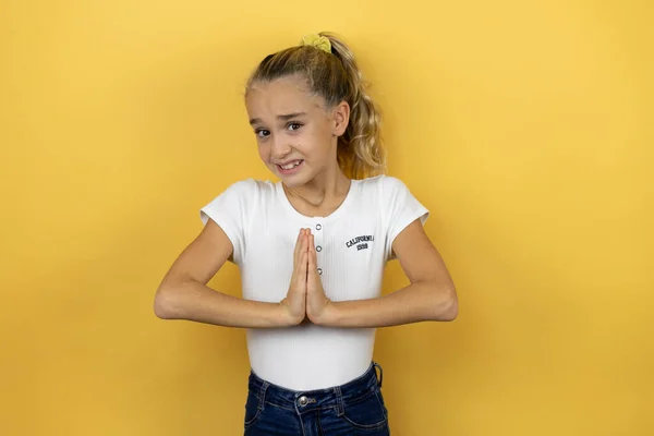 Young Beautiful Child Girl Standing Isolated Yellow Background Begging Praying — Stock Photo, Image