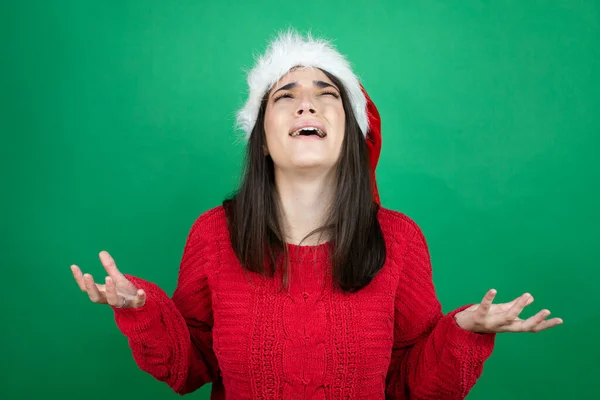 Junge Schöne Frau Mit Weihnachtsmütze Über Isoliertem Grünem Hintergrund Verrückt — Stockfoto