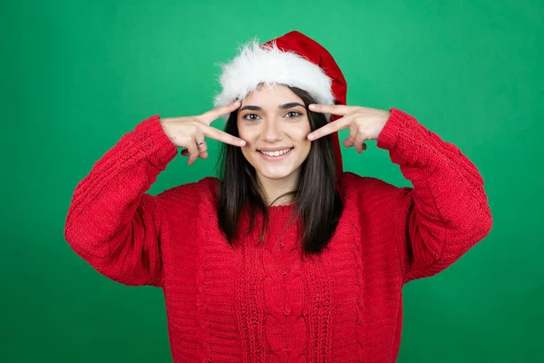 Joven Hermosa Mujer Vistiendo Sombrero Navidad Santa Sobre Fondo Verde — Foto de Stock