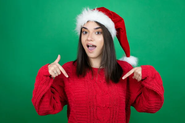 Noel Baba Şapkası Takan Genç Güzel Bir Kadın Yeşil Arka — Stok fotoğraf