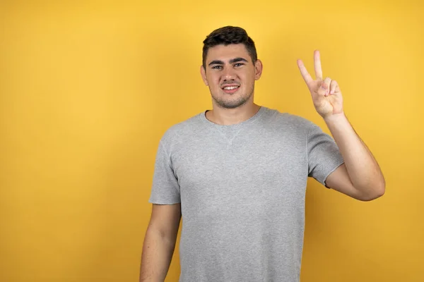 Joven Hombre Guapo Con Una Camiseta Casual Sobre Fondo Amarillo — Foto de Stock