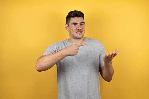 Joven Hombre Guapo Con Una Camiseta Casual Sobre Fondo Amarillo — Foto de Stock