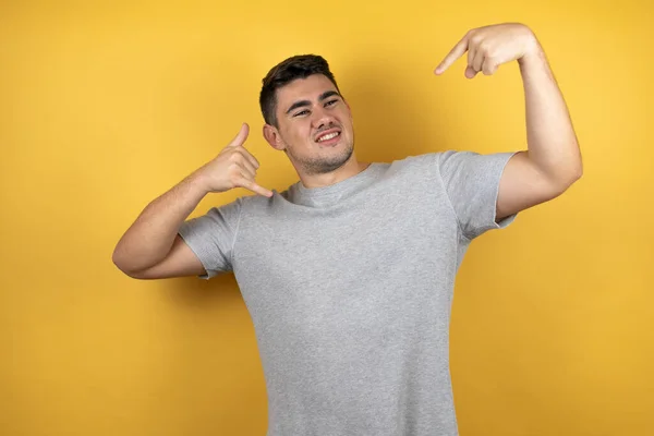 Joven Hombre Guapo Con Una Camiseta Casual Sobre Fondo Amarillo — Foto de Stock