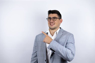 İş adamı beyaz arka plan üzerine sıradan bir gömlek giyen genç adam el ve parmak ile yan tarafı işaret ederek şaşırdı