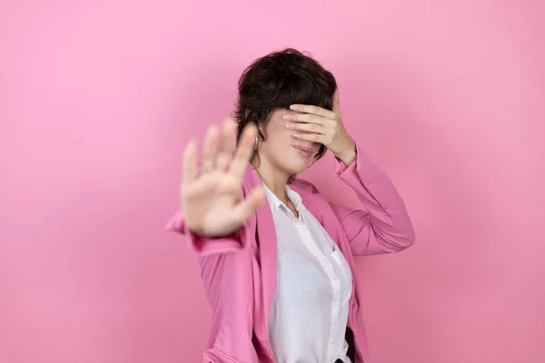 Молода Ділова Жінка Над Ізольованим Рожевим Тлом Покриває Очі Руками — стокове фото