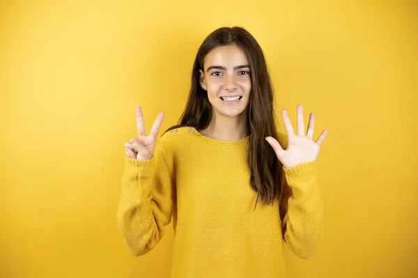 Pretty Girl Wearing Yellow Sweater Standing Isolated Yellow Background Showing — Zdjęcie stockowe