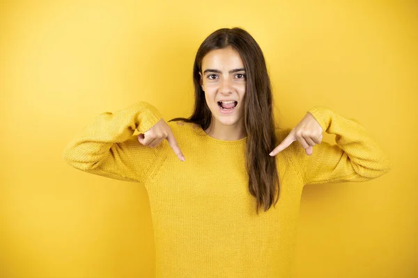 Pretty Girl Wearing Yellow Sweater Standing Isolated Yellow Background Looking — Zdjęcie stockowe