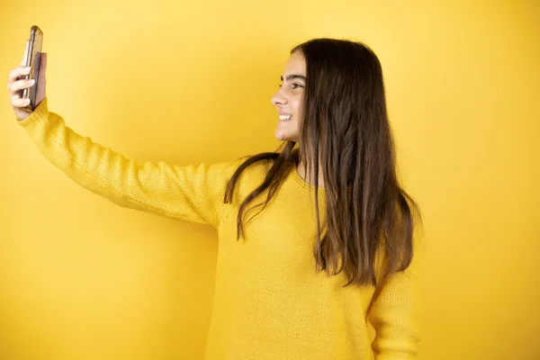 Pretty Girl Wearing Yellow Sweater Standing Isolated Yellow Background Taking — Stock Fotó