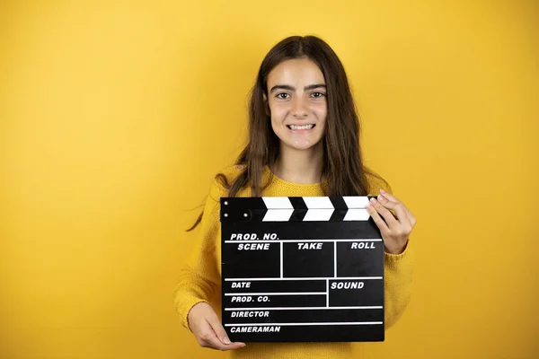 Pretty Girl Wearing Yellow Sweater Standing Isolated Yellow Background Holding — Zdjęcie stockowe