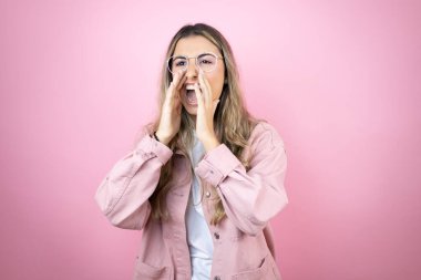 Pembe arka planda duran uzun saçlı güzel sarışın kadın elleri ağızda bağırıp çağırıyordu.