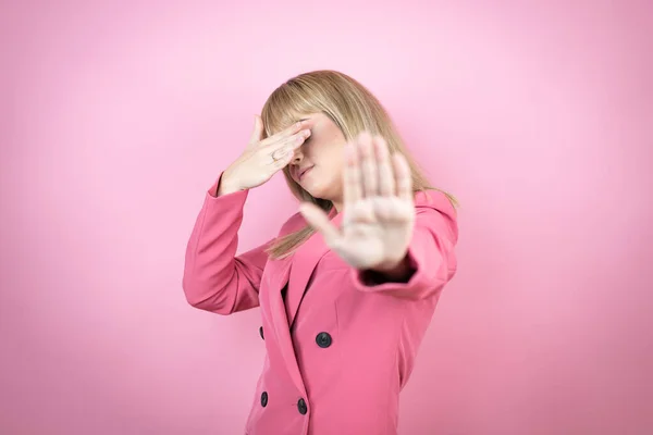 Молода Біла Жінка Над Ізольованим Рожевим Тлом Покриває Очі Руками — стокове фото