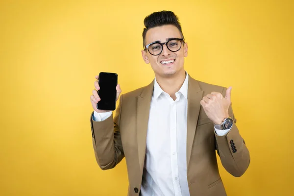 Junger Geschäftsmann Auf Gelbem Hintergrund Lächelt Zeigt Das Telefon Und — Stockfoto