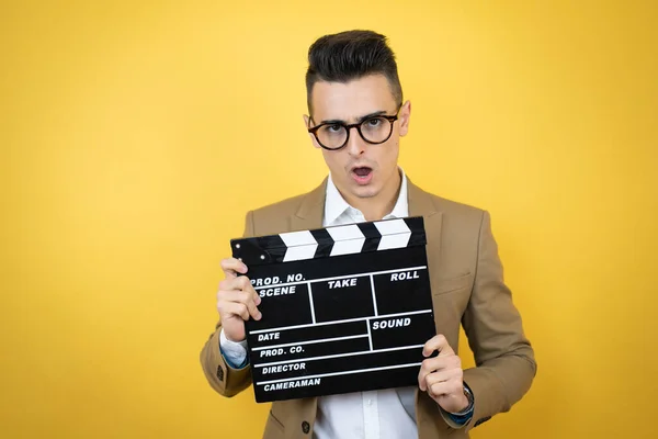 Joven Hombre Negocios Sobre Fondo Amarillo Aislado Sosteniendo Clapperboard Muy — Foto de Stock