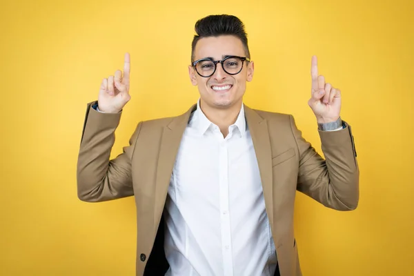 Junger Geschäftsmann Auf Gelbem Hintergrund Lächelt Die Kamera Und Zeigt — Stockfoto