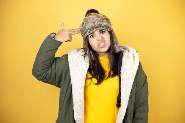 Sarı arka planda yeşil ceketli, şapkalı güzel bir kadın kendini ve parmaklarını silah gibi gösteren birini vuruyor, öldürüyor, intihar ediyor..