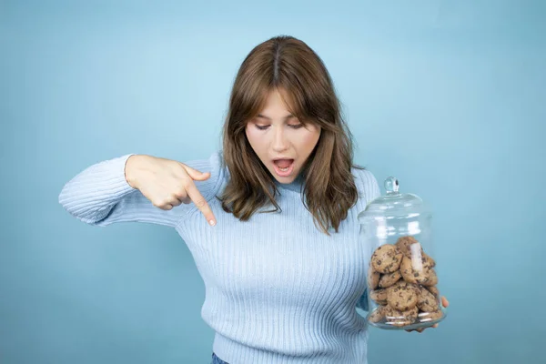 Young Beautiful Woman Holding Chocolate Chips Cookies Jar Isolated Blue — Stock Photo, Image