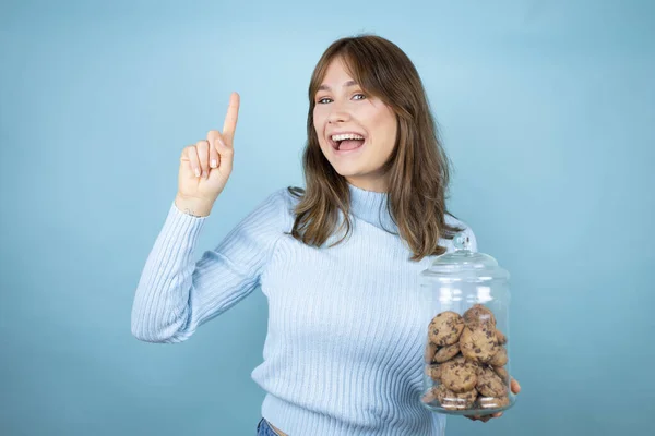 Young Beautiful Woman Holding Chocolate Chips Cookies Jar Isolated Blue — Stock Photo, Image