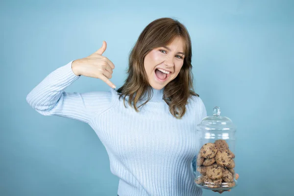 Young Beautiful Woman Holding Chocolate Chips Cookies Jar Isolated Blue — Stock Photo, Image