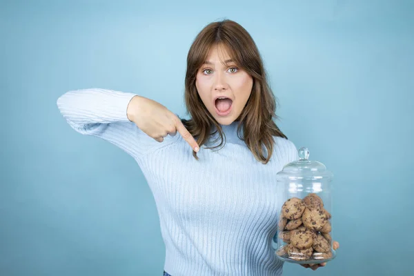 Young Beautiful Woman Holding Chocolate Chips Cookies Jar Isolated Blue — Stock Photo, Image