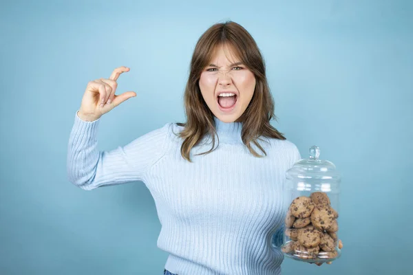 Young Beautiful Woman Holding Chocolate Chips Cookies Jar Isolated Blue — Stock Photo, Image