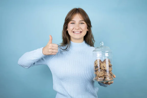 Young Beautiful Woman Holding Chocolate Chips Cookies Jar Isolated Blue — Stock Photo, Image