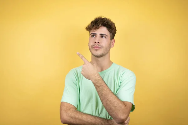 Bonito Homem Vestindo Uma Camiseta Casual Verde Sobre Fundo Amarelo — Fotografia de Stock