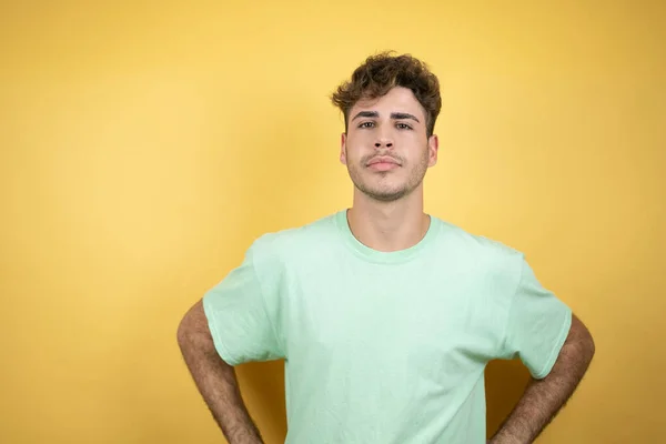 Hombre Guapo Con Una Camiseta Casual Verde Sobre Fondo Amarillo — Foto de Stock