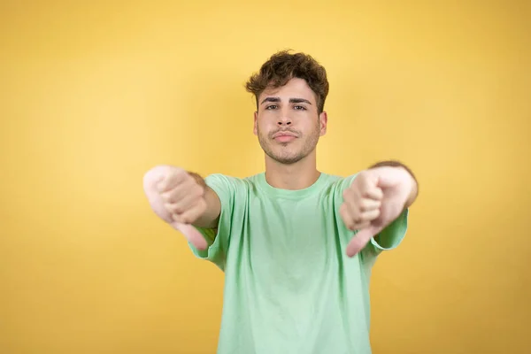 Hombre Guapo Con Una Camiseta Verde Casual Sobre Fondo Amarillo — Foto de Stock