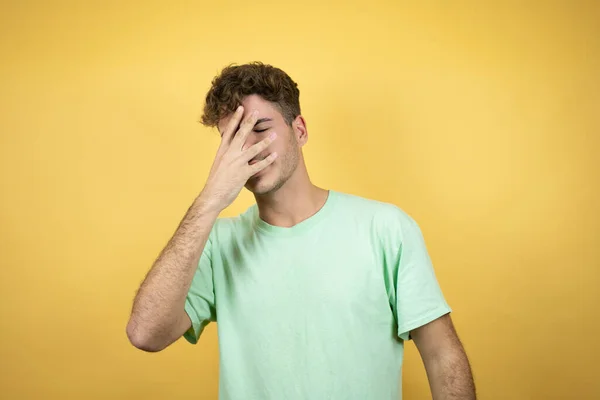Knappe Man Draagt Een Groen Casual Shirt Gele Achtergrond Gluren — Stockfoto