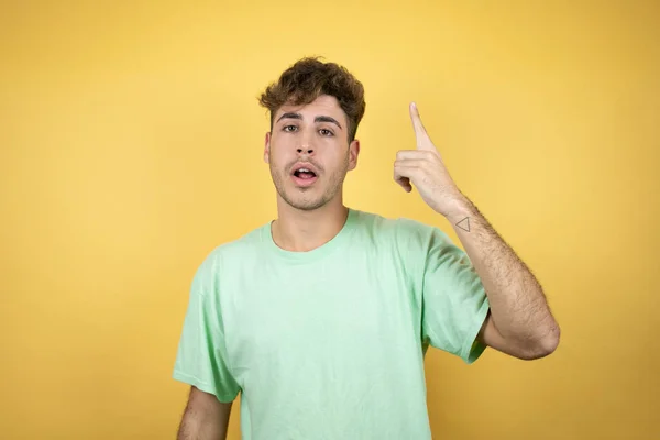 Knappe Man Draagt Een Groen Casual Shirt Gele Achtergrond Gluren — Stockfoto
