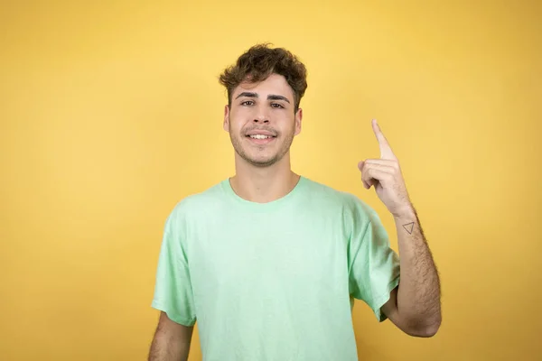 Bonito Homem Vestindo Uma Camiseta Casual Verde Sobre Fundo Amarelo — Fotografia de Stock