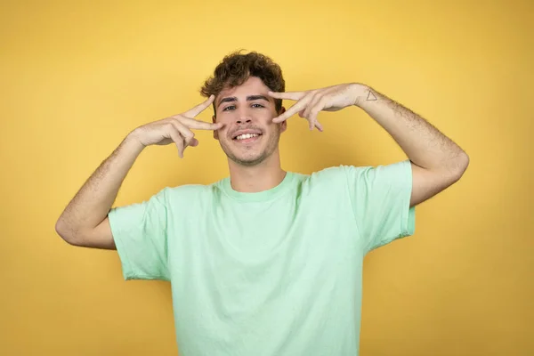 Schöner Mann Einem Grünen Lässigen Shirt Vor Gelbem Hintergrund Friedenssymbol — Stockfoto
