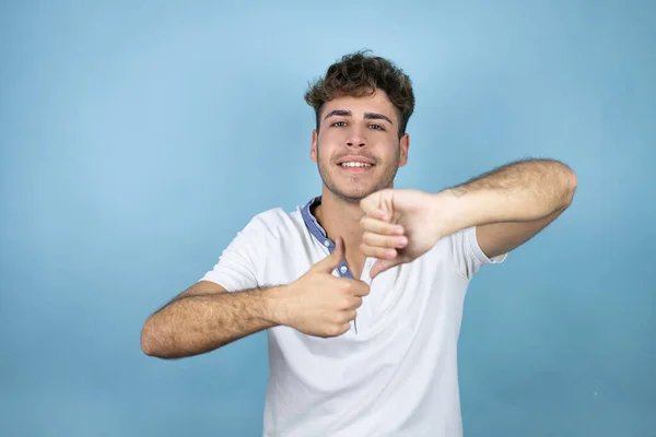 Jovem Bonitão Vestindo Uma Camiseta Branca Sobre Fundo Azul Fazendo — Fotografia de Stock