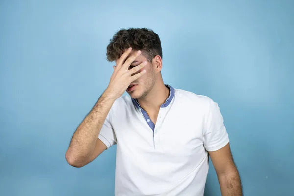 Jonge Knappe Man Draagt Een Wit Shirt Blauwe Achtergrond Gluurend — Stockfoto