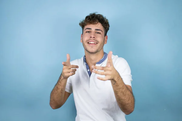Jonge Knappe Man Draagt Een Wit Shirt Blauwe Achtergrond Wijzend — Stockfoto