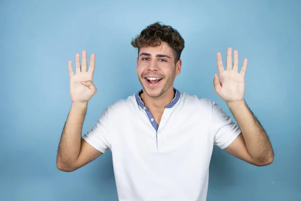 Junger Gutaussehender Mann Trägt Ein Weißes Shirt Über Blauem Hintergrund — Stockfoto