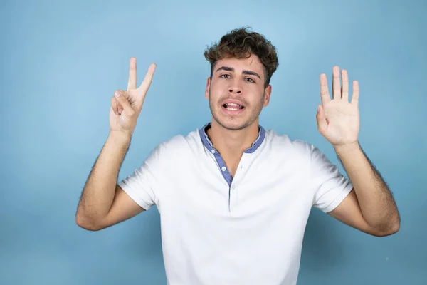 Jonge Knappe Man Draagt Een Wit Shirt Blauwe Achtergrond Tonen — Stockfoto