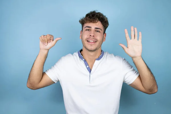 Junger Gutaussehender Mann Trägt Ein Weißes Shirt Über Blauem Hintergrund — Stockfoto