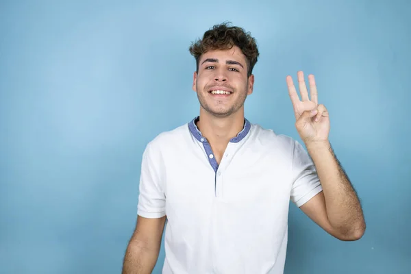 Joven Hombre Guapo Con Una Camiseta Blanca Sobre Fondo Azul — Foto de Stock