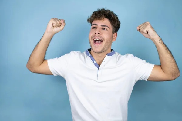 Mavi Arka Planda Beyaz Tişört Giyen Yakışıklı Genç Adam Mutlu — Stok fotoğraf