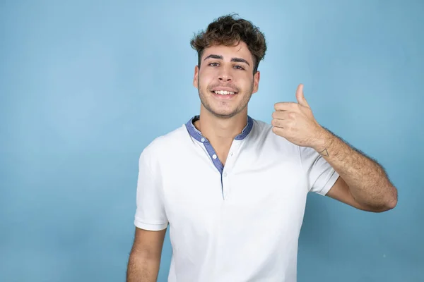 Jonge Knappe Man Draagt Een Wit Shirt Blauwe Achtergrond Glimlachend — Stockfoto